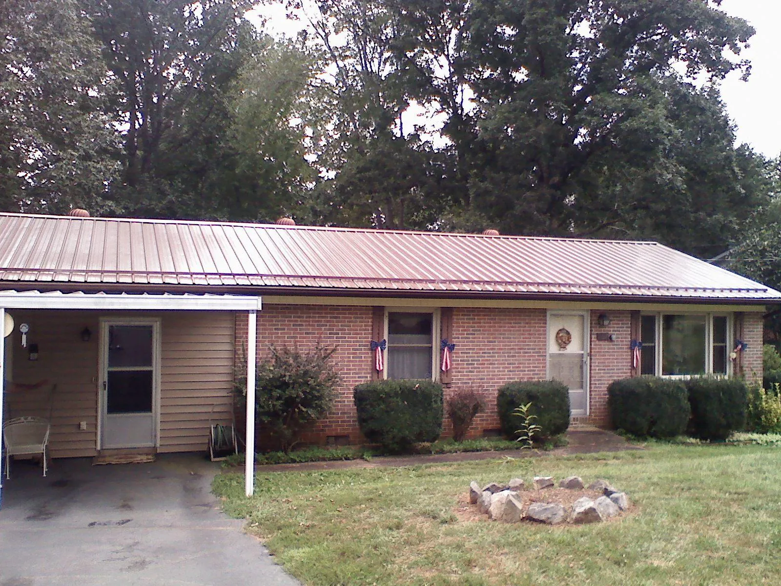 Bronze metal roof and carport on a brick ranch home — Roof Repair work by our crew in Forest Park